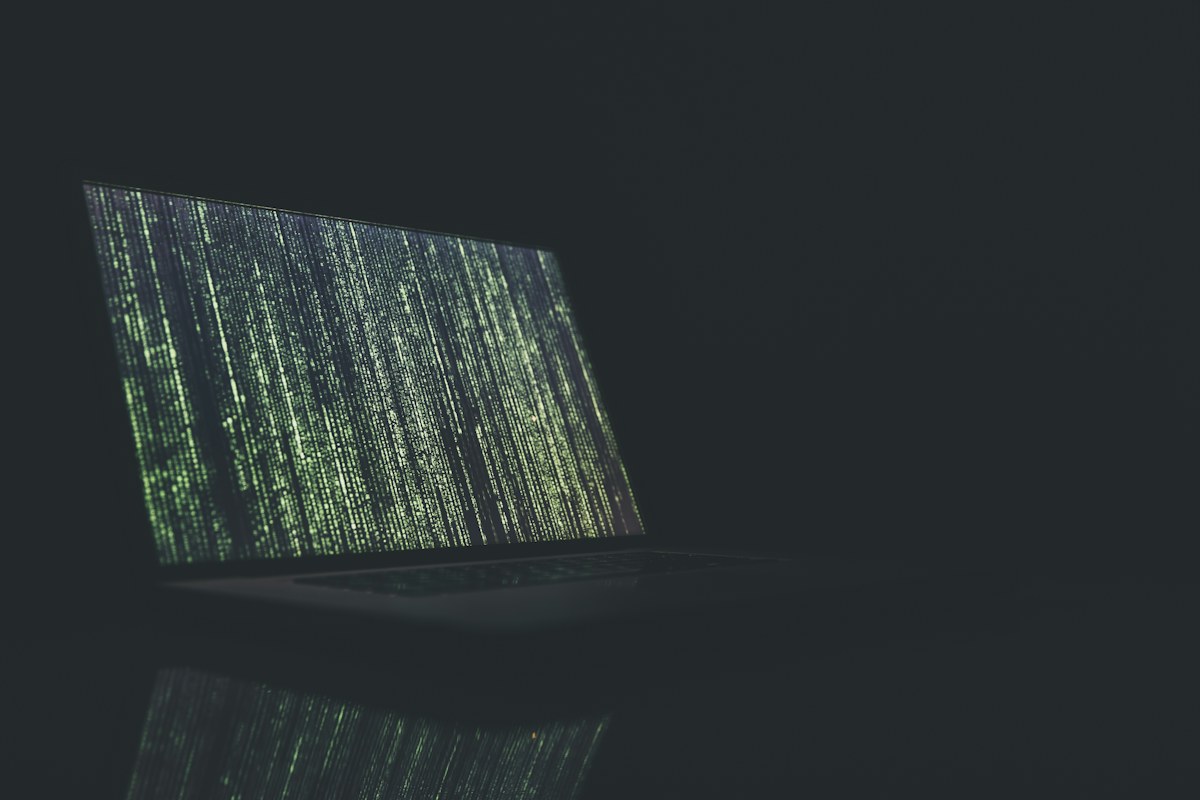 Notebook com tela exibindo códigos, representando segurança digital e análise de acesso remoto